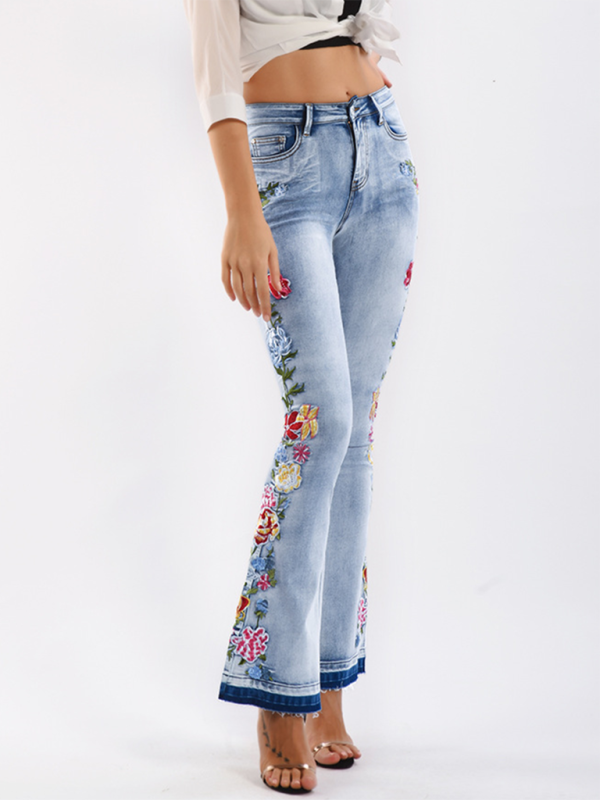 Light blue jeans with floral embroidery on a white background