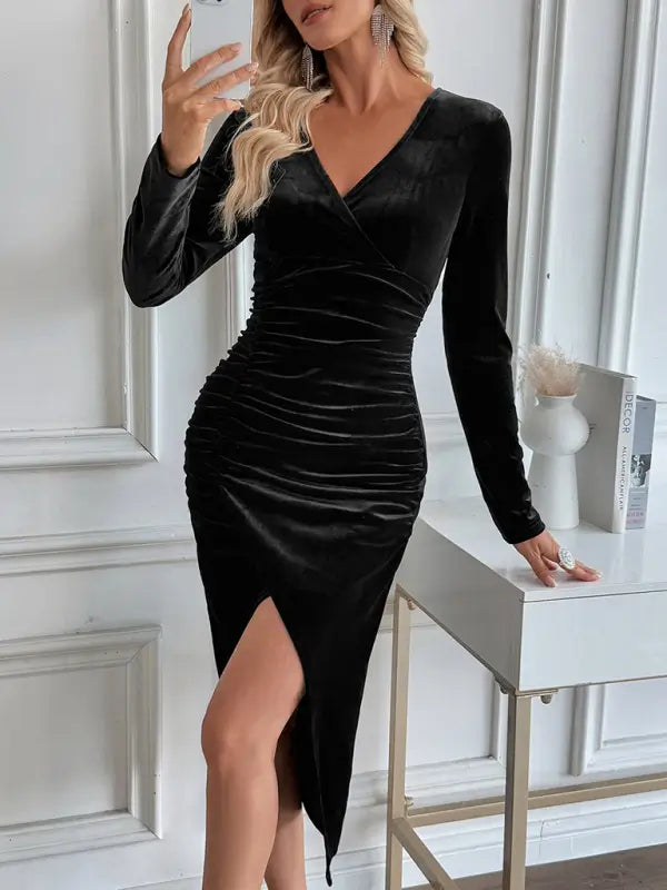 Woman wearing a black velvet dress with long sleeves in an elegant room.